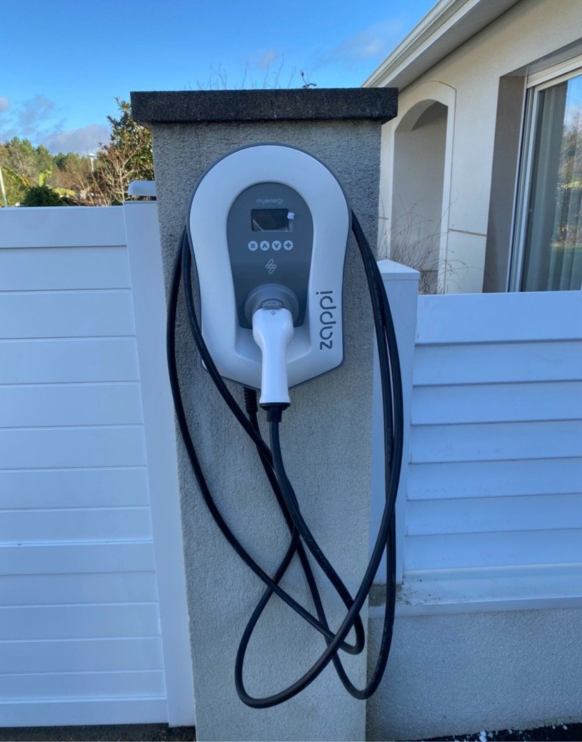 Borne de recharge Zappi installée sur un pilier extérieur avec câble de recharge pour véhicule électrique.