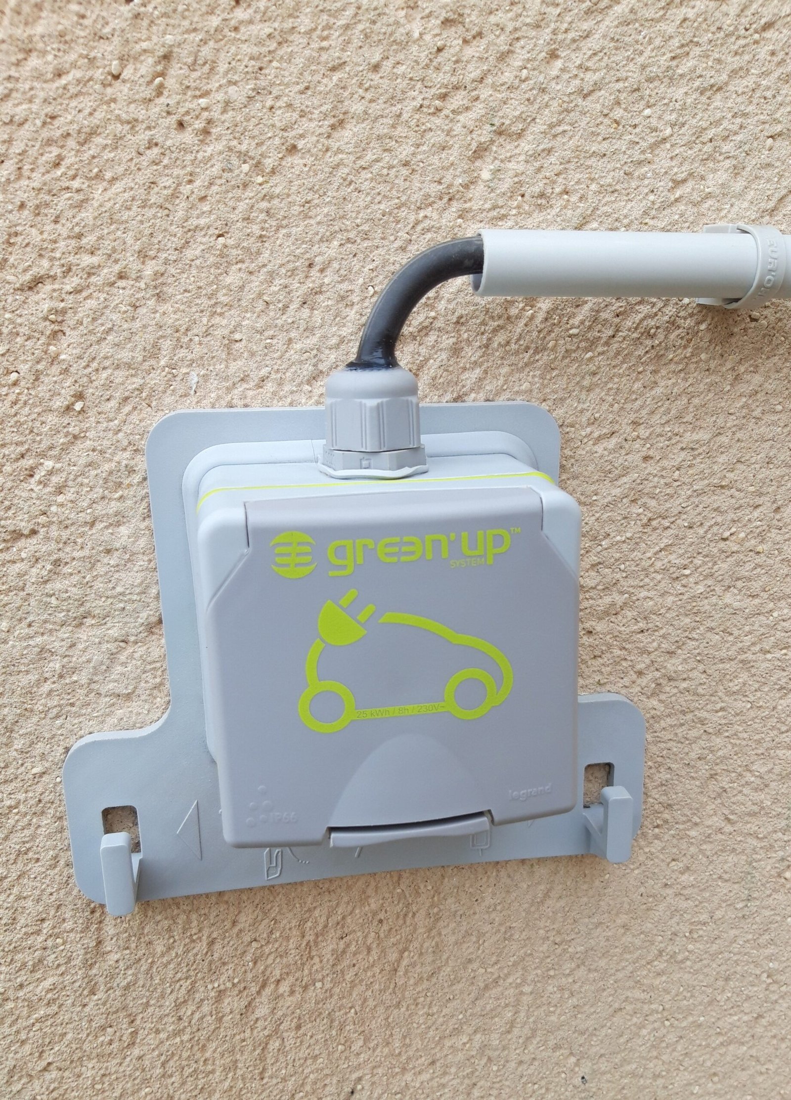 Installation d’une prise Green’Up pour la recharge d’un véhicule électrique sur mur extérieur.
